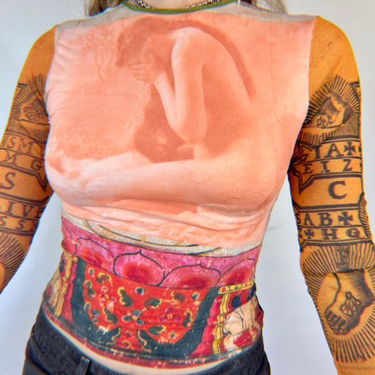 Long sleeve top with crying woman on front, yellow sleeves with religious symbols on them
