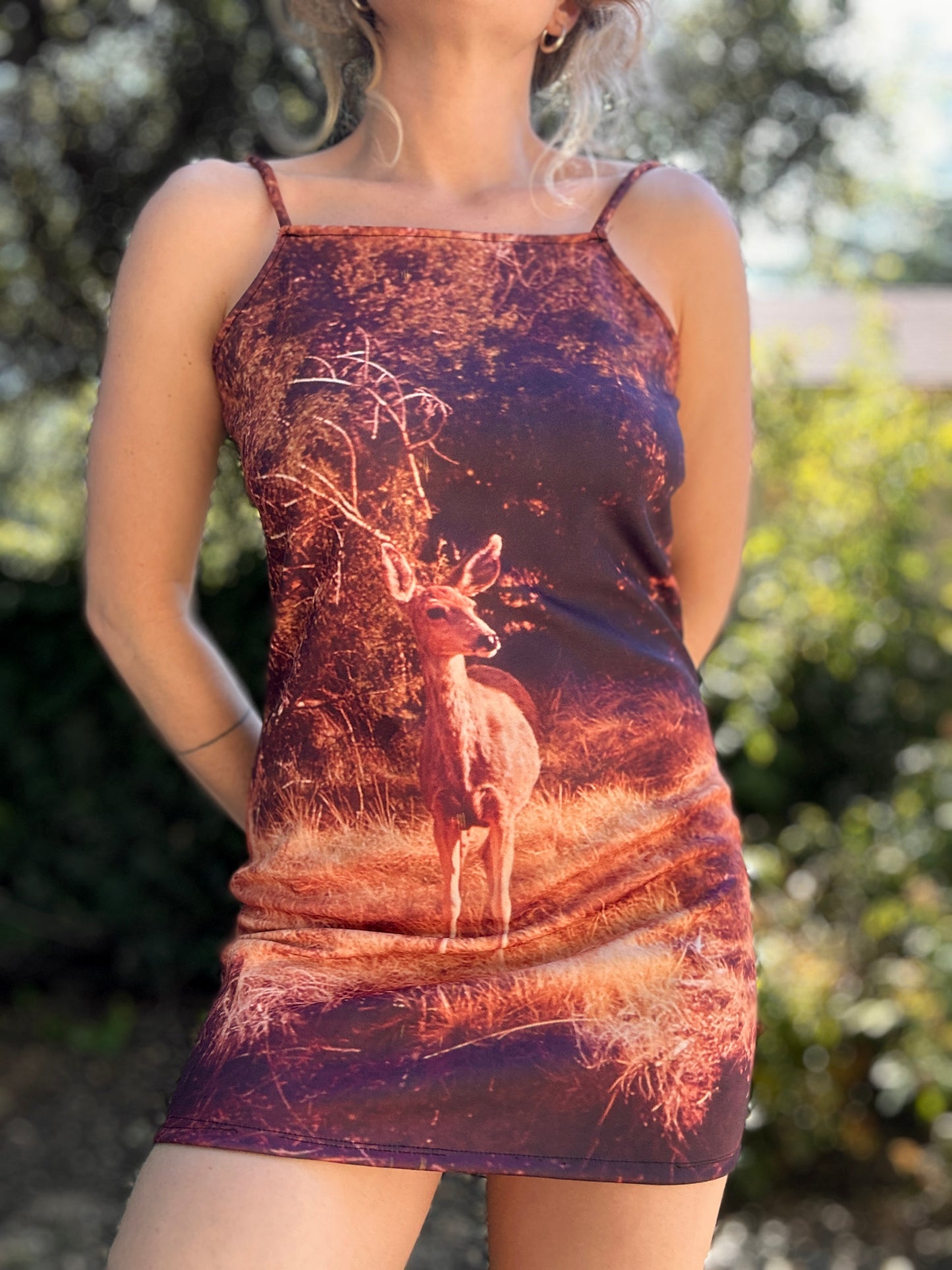 Mini dress with spaghetti straps featuring a deer in a grassy clearing.